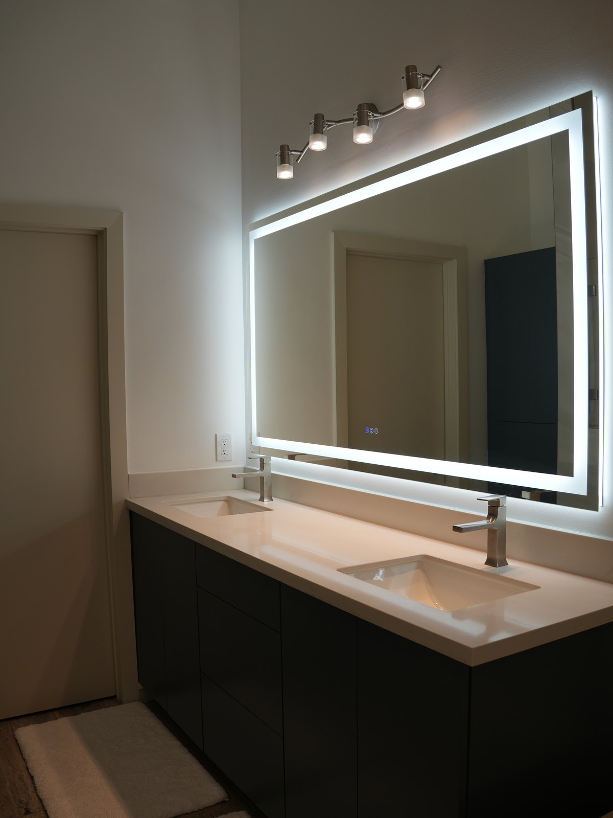 Bathroom remodel by Haven Renovations — double vanity with quartz top and backlit mirror