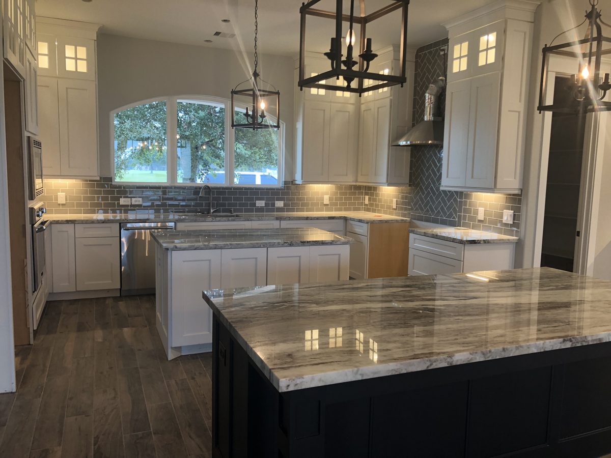 Custom kitchen by Haven Renovations — painted cabinetry, dark island