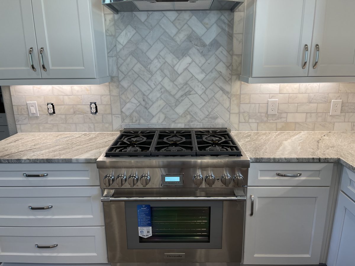 Custom kitchen by Haven Renovations — stone tile, professional range