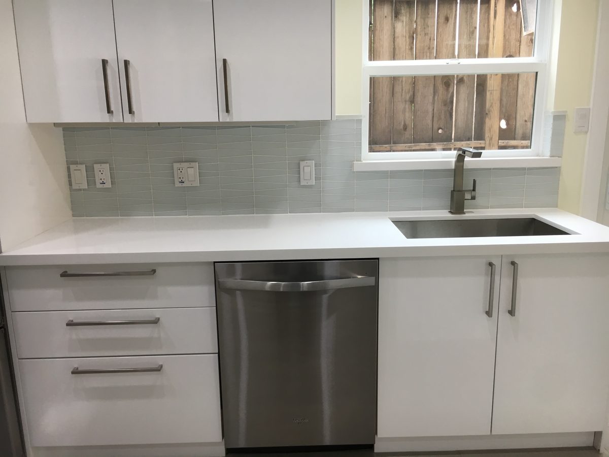 Custom kitchen by Haven Renovations — glass tile, stone counters