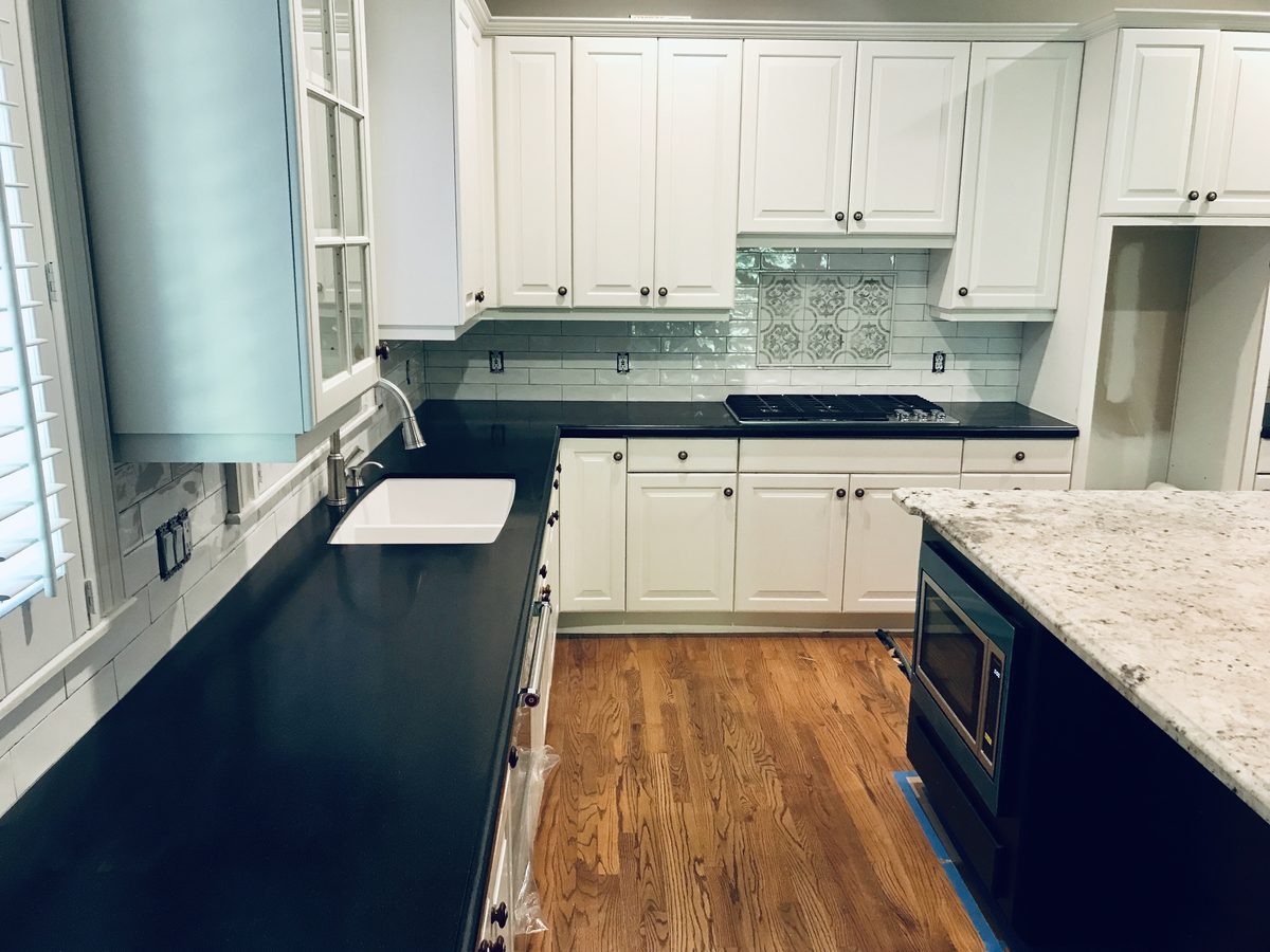 Custom kitchen by Haven Renovations — dark counters, wood floors