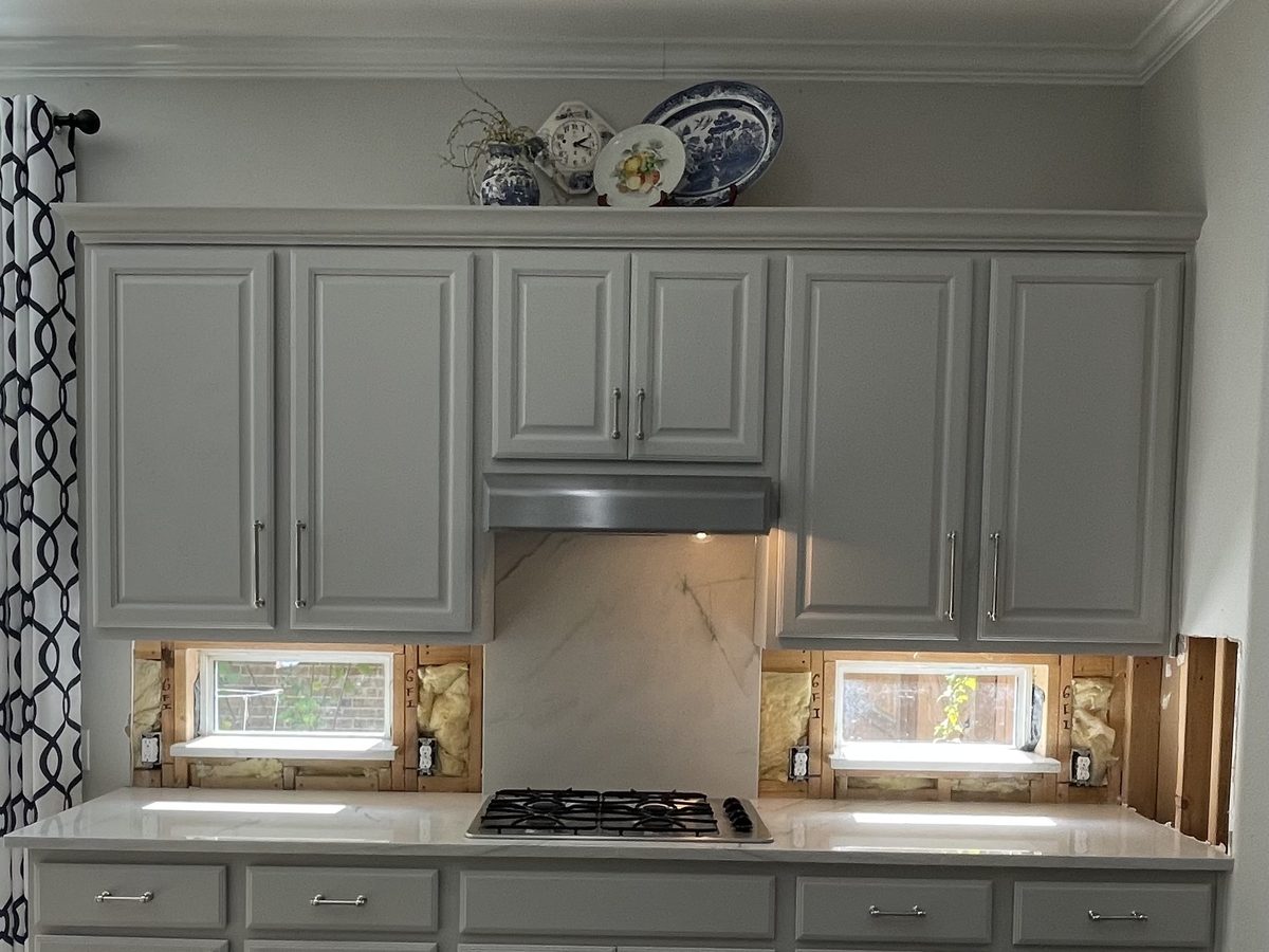 Custom kitchen by Haven Renovations — gray cabinetry, vent hood