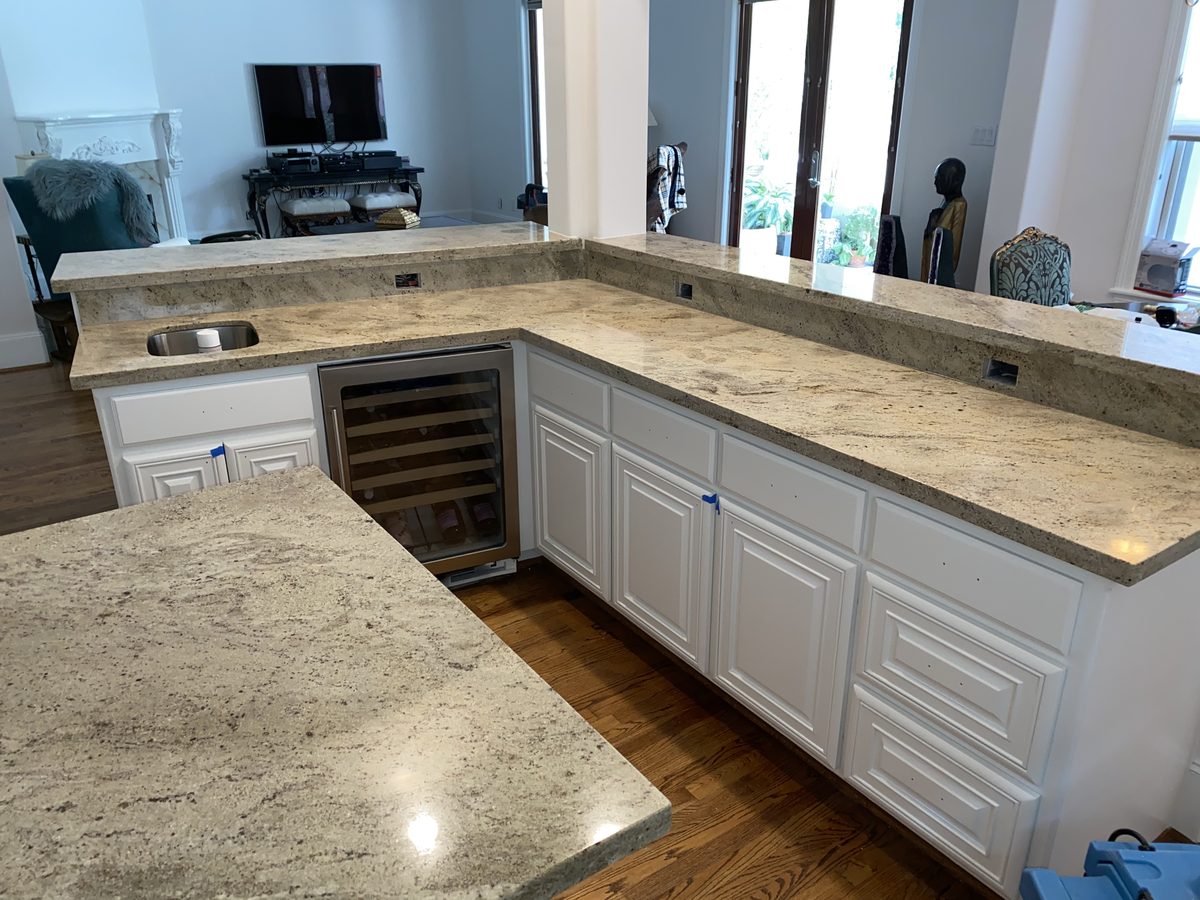 Custom kitchen by Haven Renovations — wine storage, stone tops