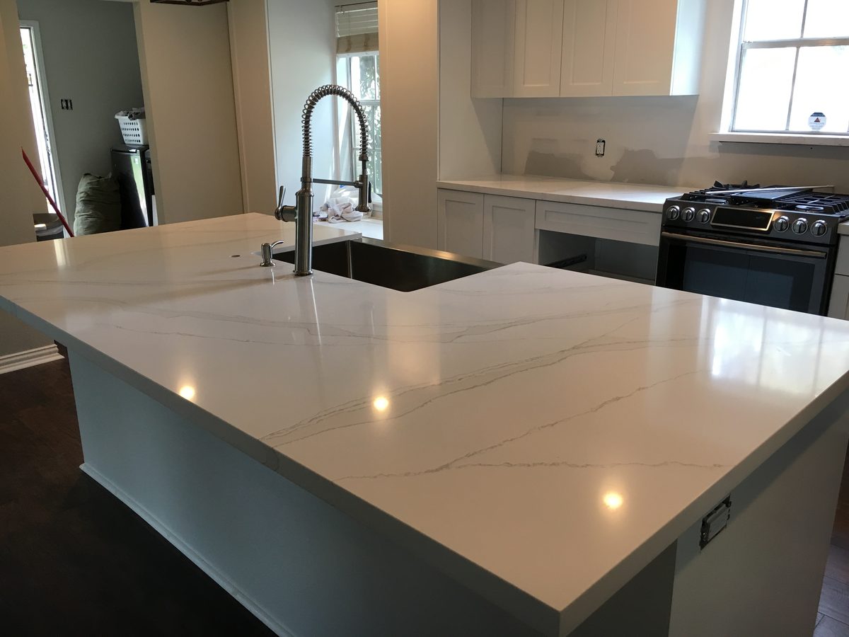 Custom kitchen by Haven Renovations — flat-panel cabinetry, stone top