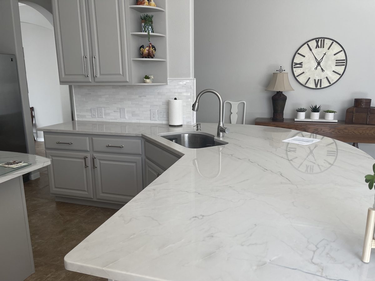 Custom kitchen by Haven Renovations — painted cabinetry, veined stone