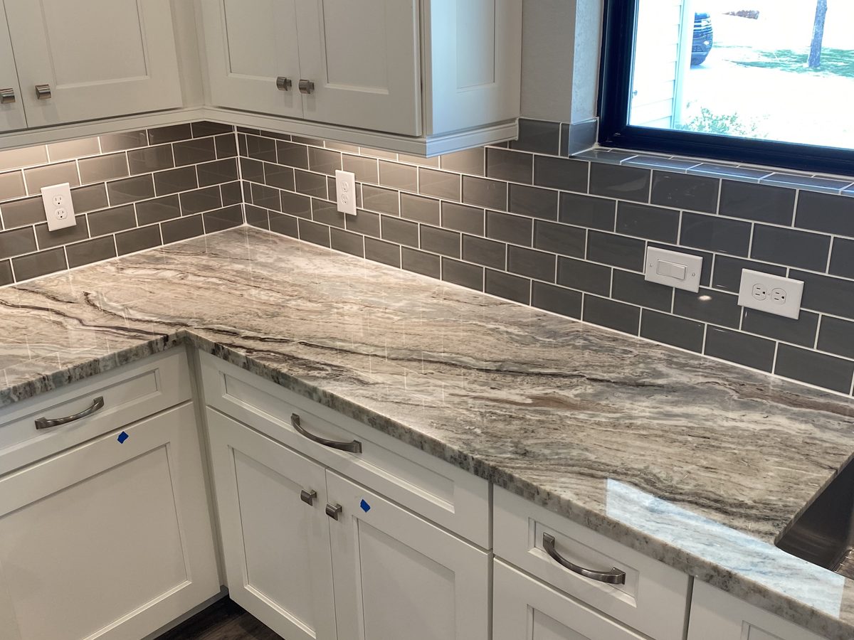 Custom kitchen by Haven Renovations — gray tile, stone counters