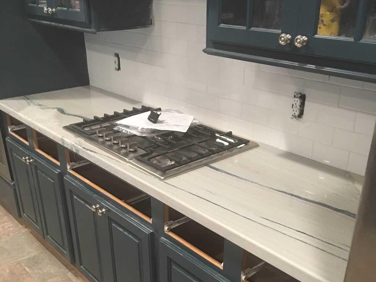 Custom kitchen by Haven Renovations — blue-gray cabinetry, stone tops