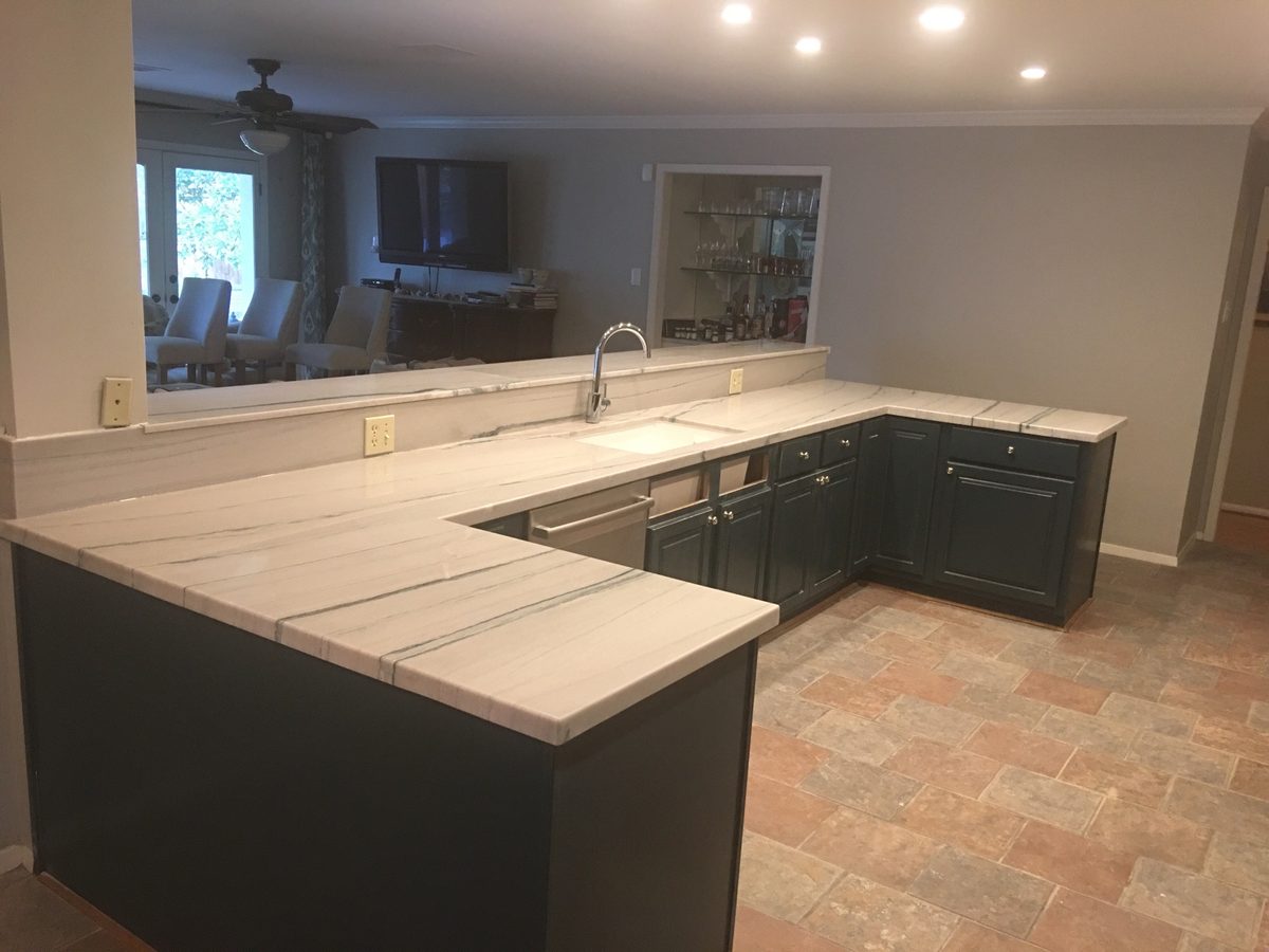 Custom kitchen by Haven Renovations — dark cabinetry, stone counters