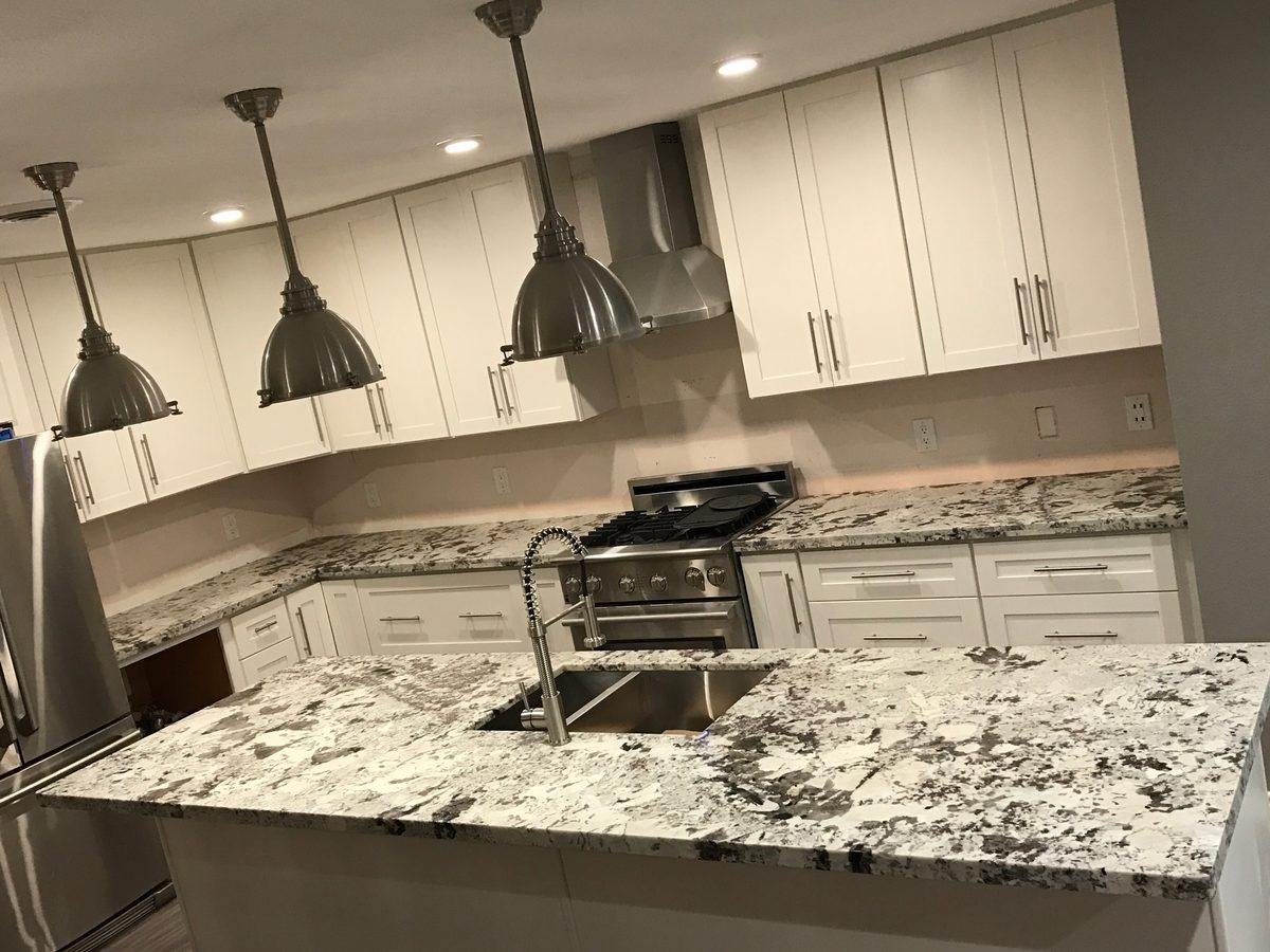 Custom kitchen by Haven Renovations — white cabinetry, undermount sink