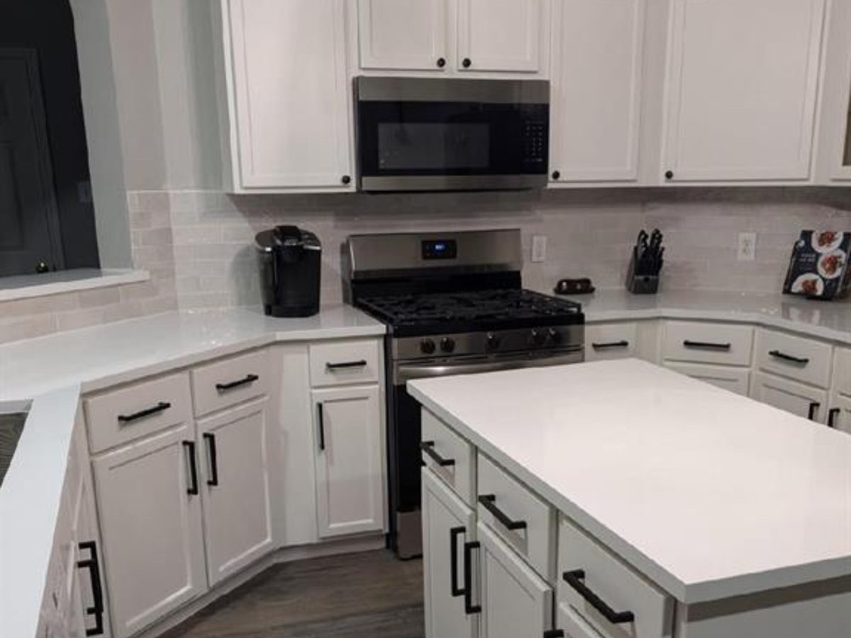 Custom kitchen by Haven Renovations — white cabinetry, island prep