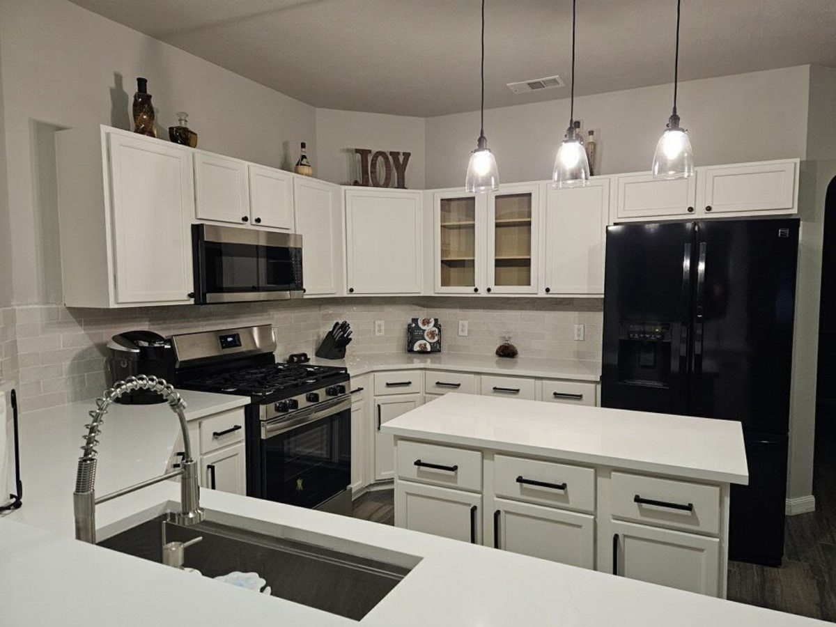 Custom kitchen by Haven Renovations — white cabinetry, pendant lighting