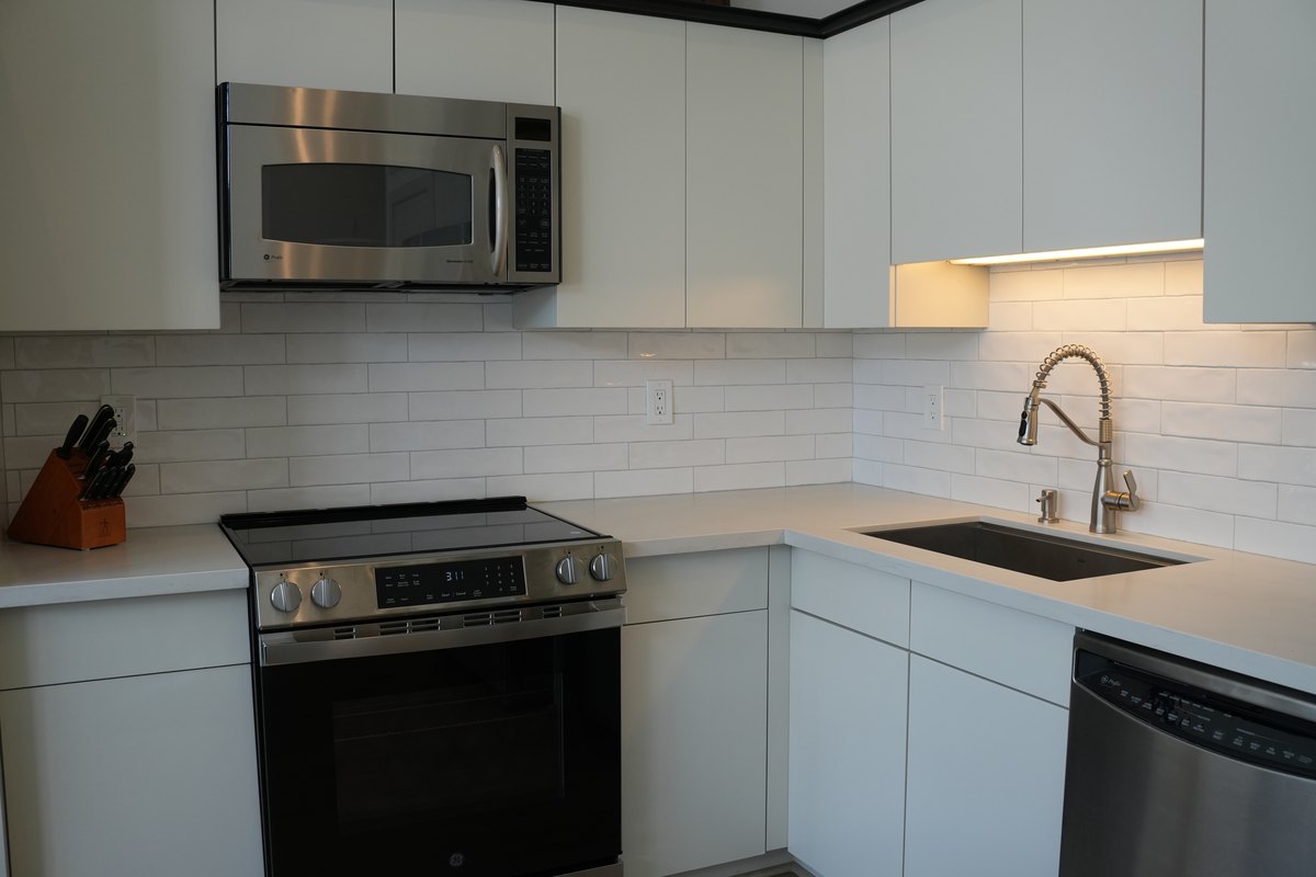 Custom kitchen by Haven Renovations — flat-panel cabinetry with quartz counters and subway backsplash