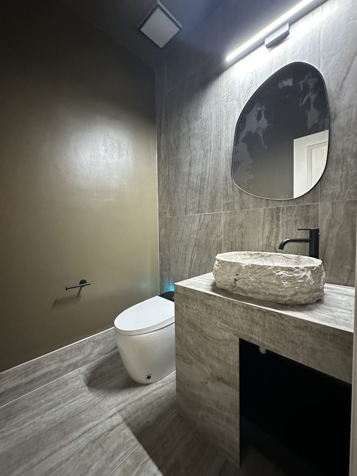 Moody powder room with stone vessel sink