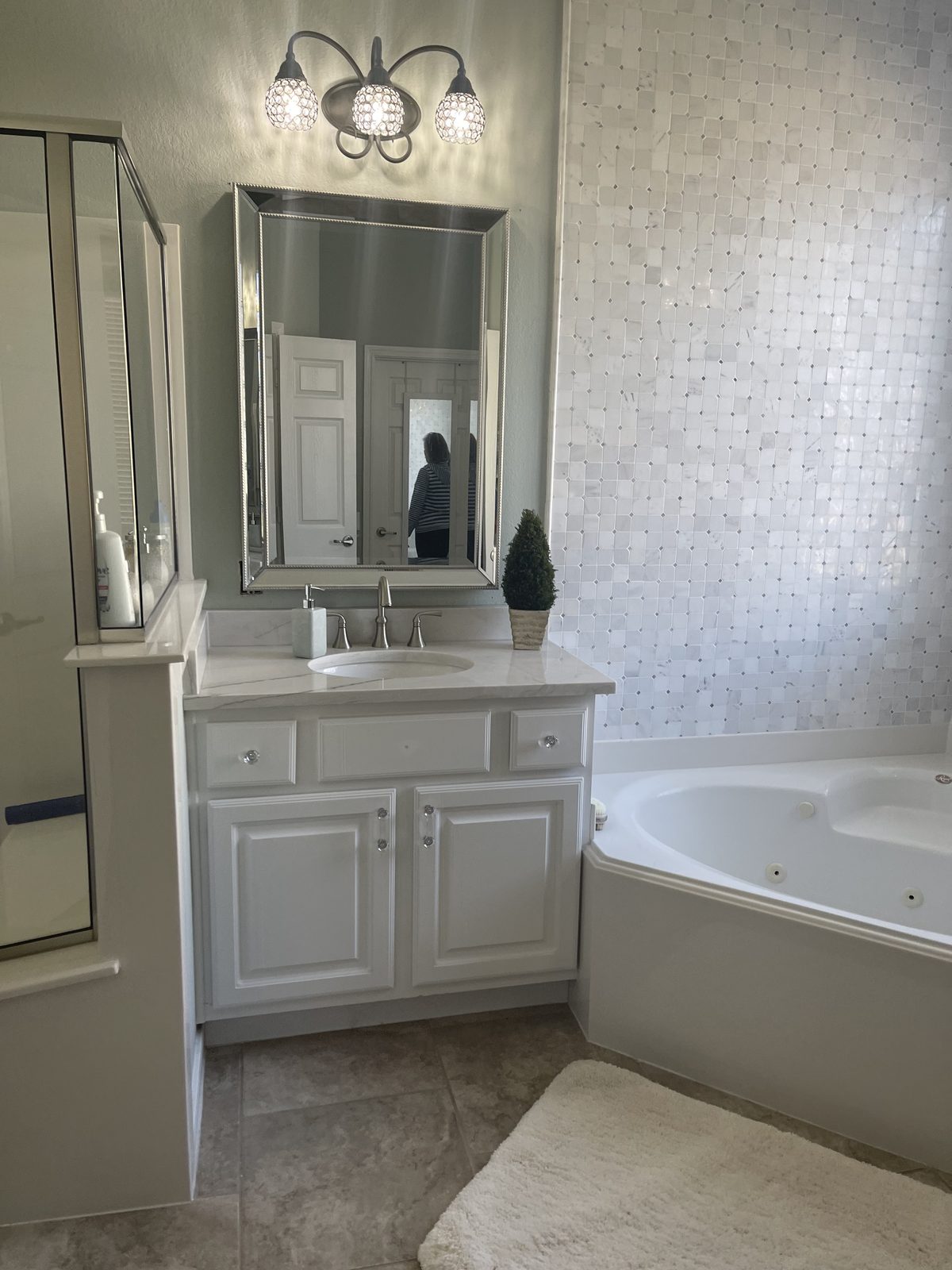 Corner tub and vanity with mosaic tile accents