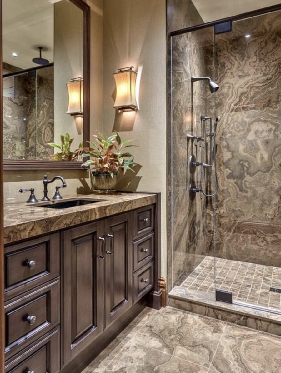 Onyx-tile shower with dark vanity and brass fixtures