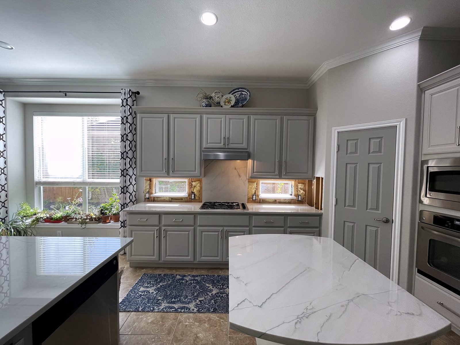 Custom kitchen by Haven Renovations — slab backsplash, quartz tops