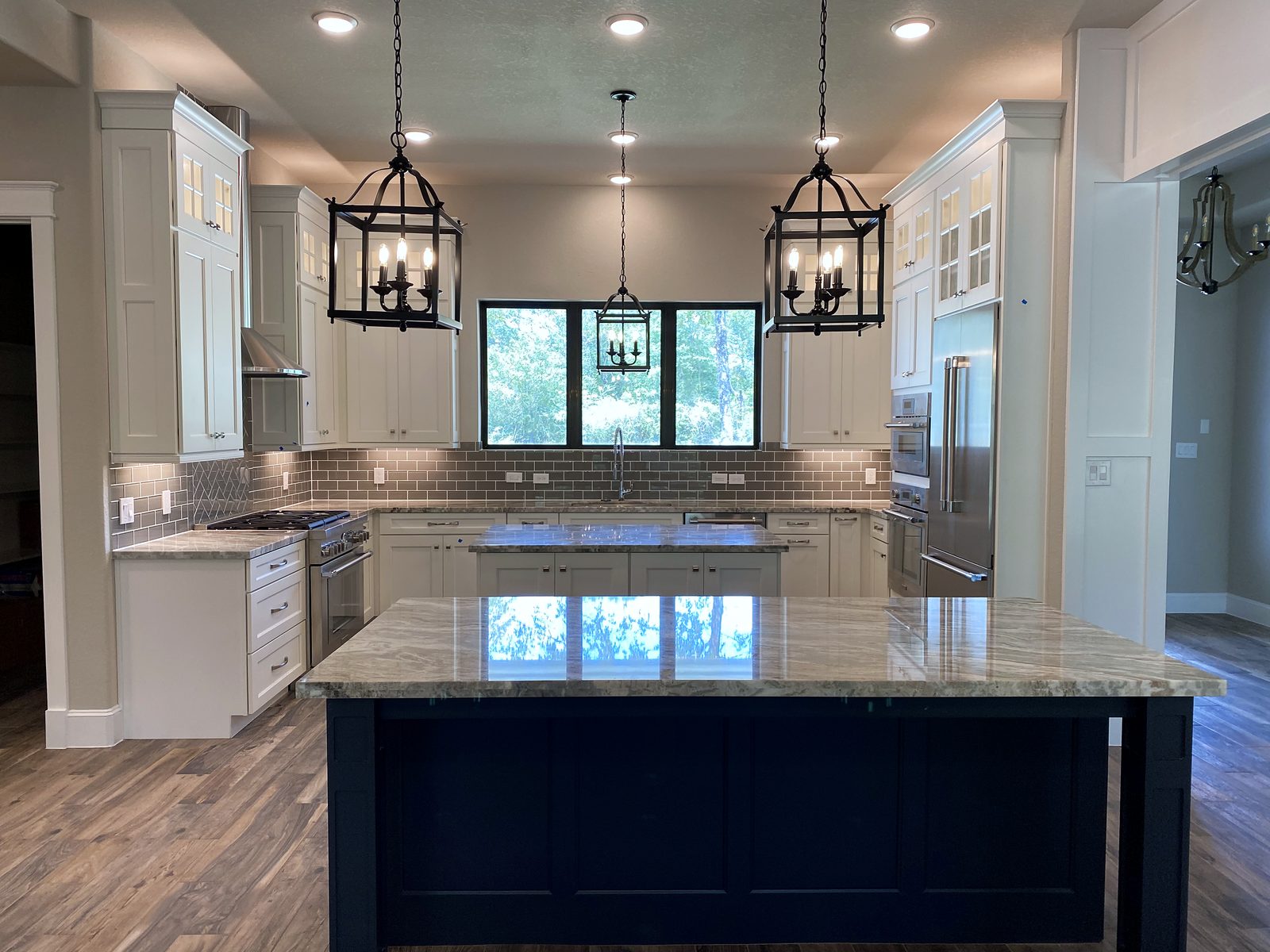 Custom kitchen by Haven Renovations — lantern pendants, granite