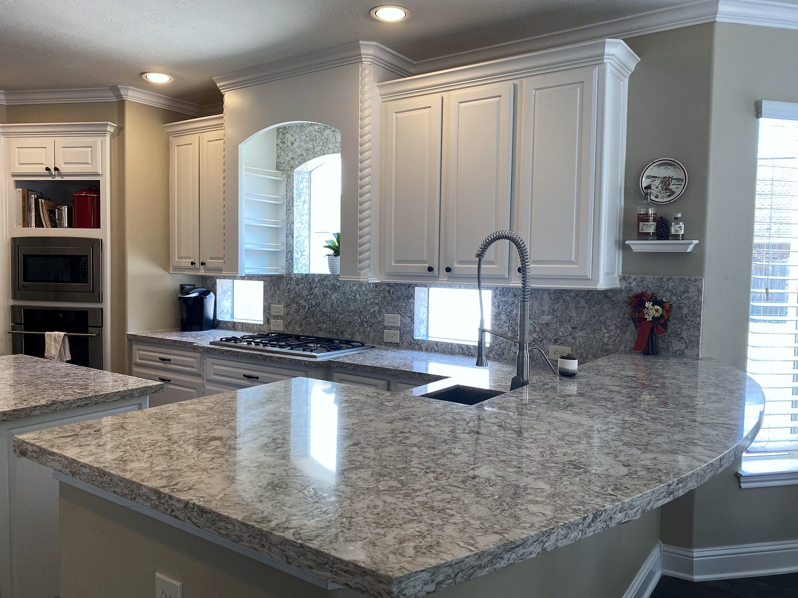 Custom kitchen by Haven Renovations — speckled granite, bar seating