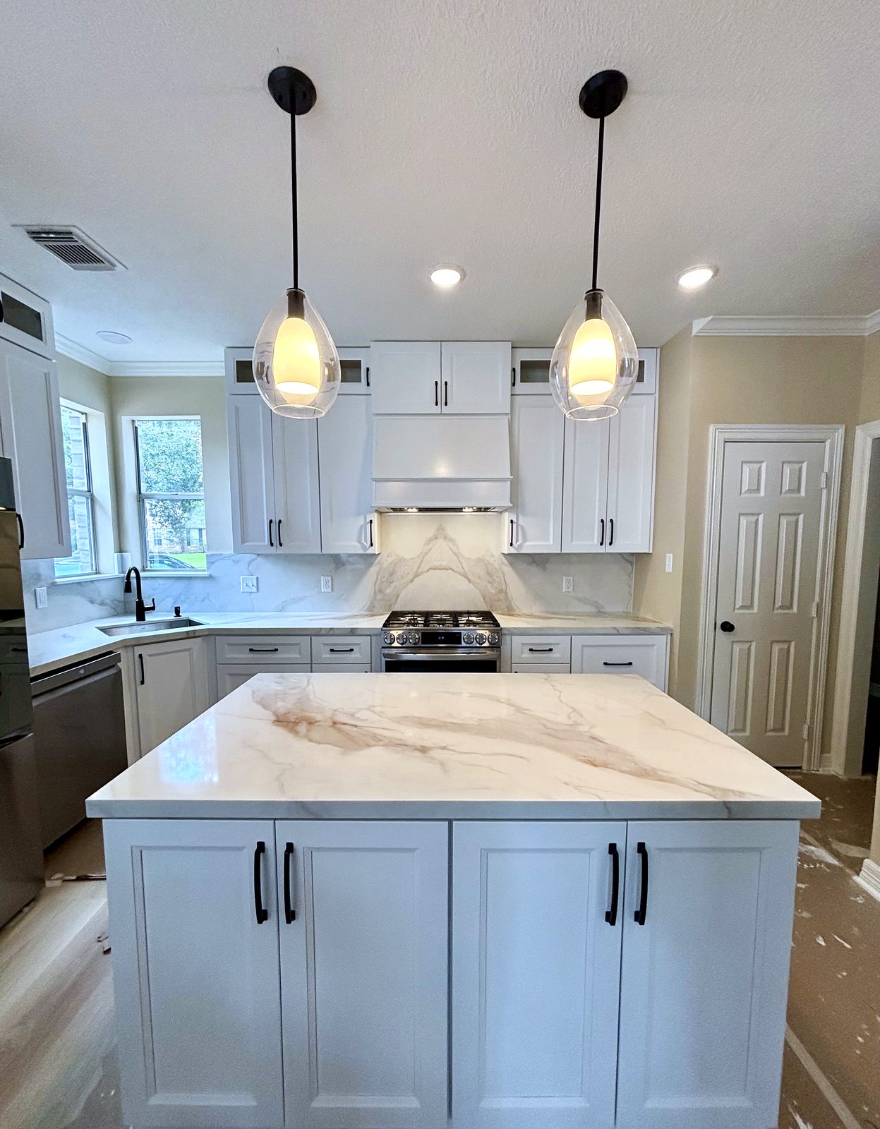 Custom kitchen by Haven Renovations — brass hardware, white shaker