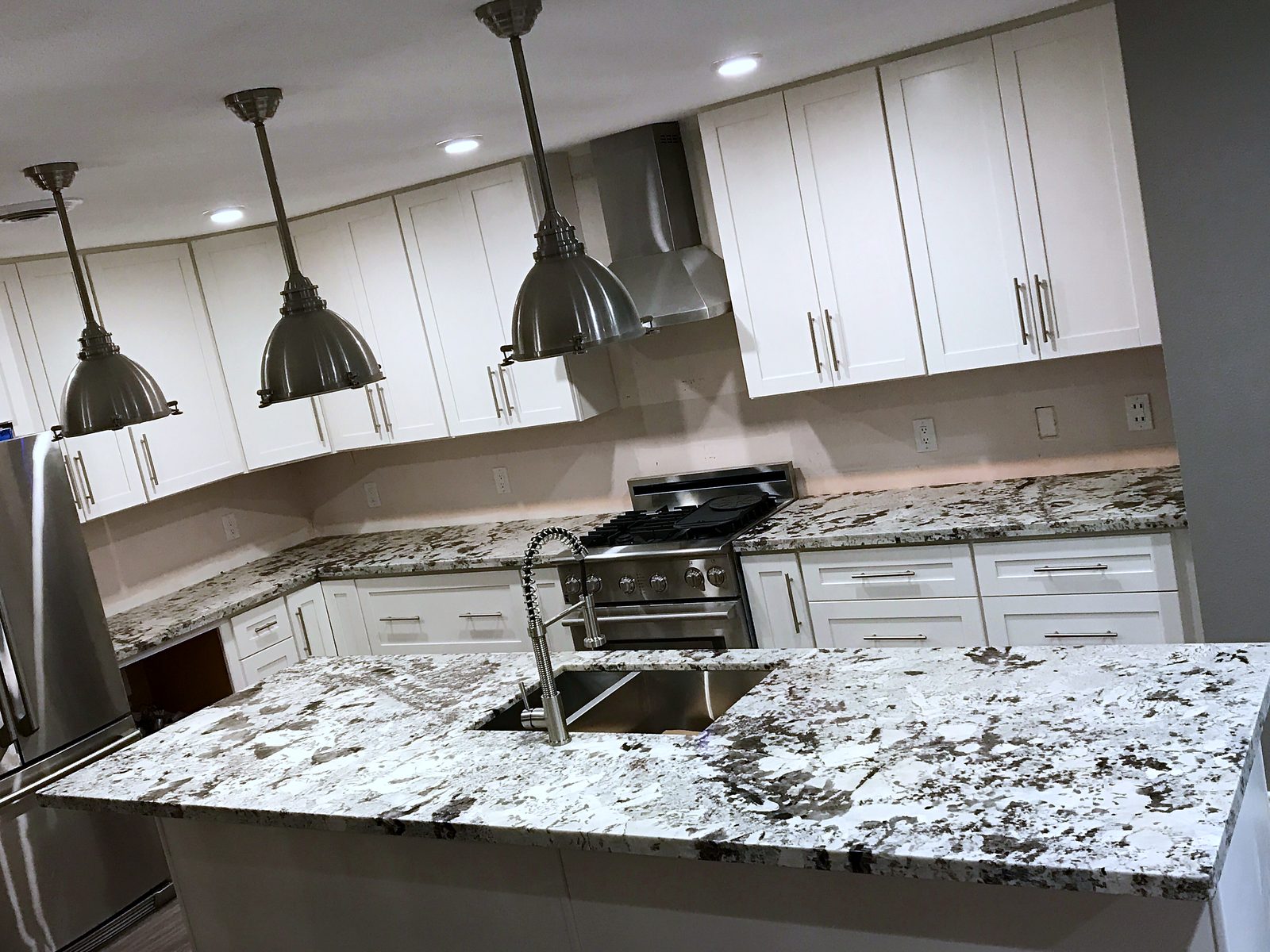 Custom kitchen by Haven Renovations — speckled granite, stainless range