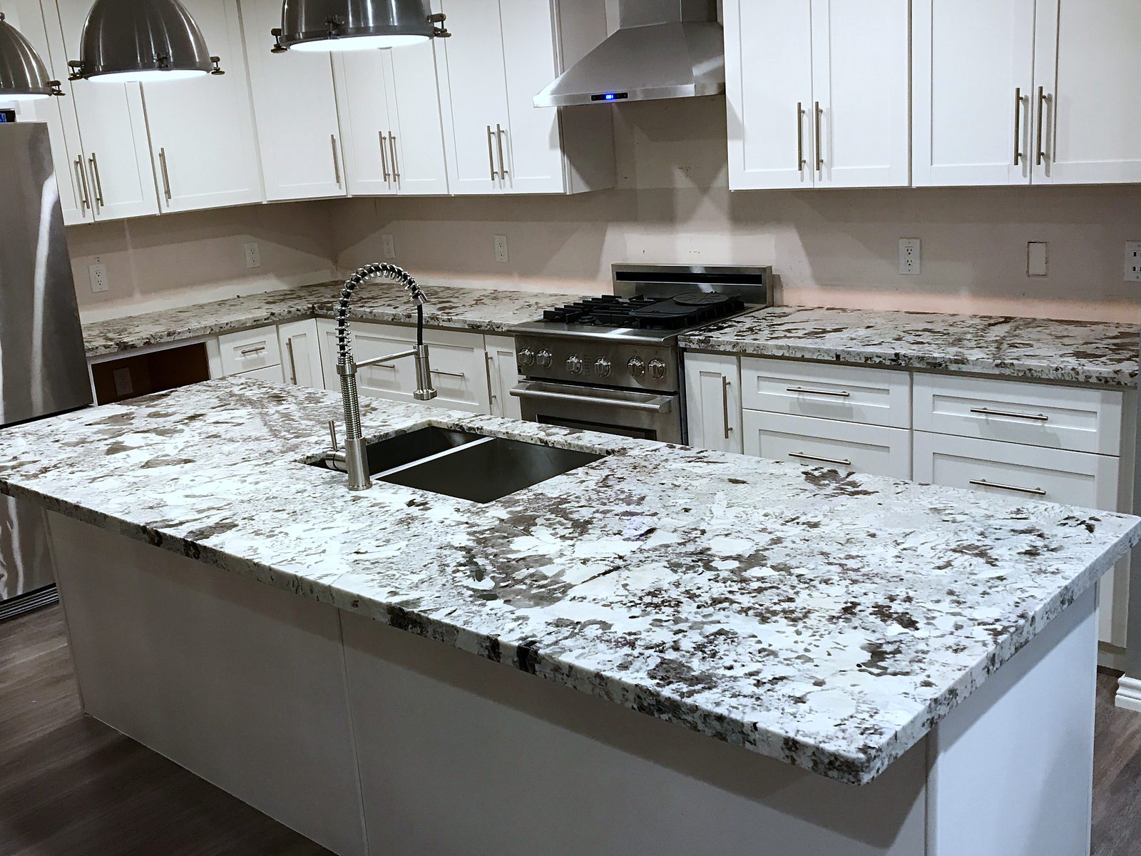 Custom kitchen by Haven Renovations — speckled granite, white shaker
