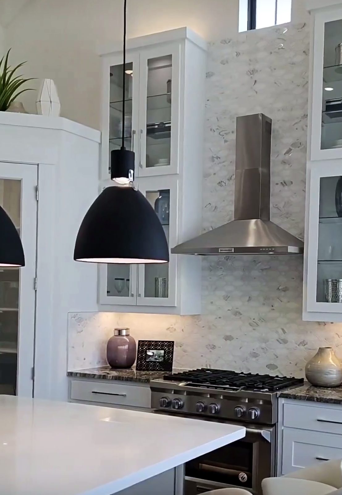 Custom kitchen by Haven Renovations — stone surround, glass uppers