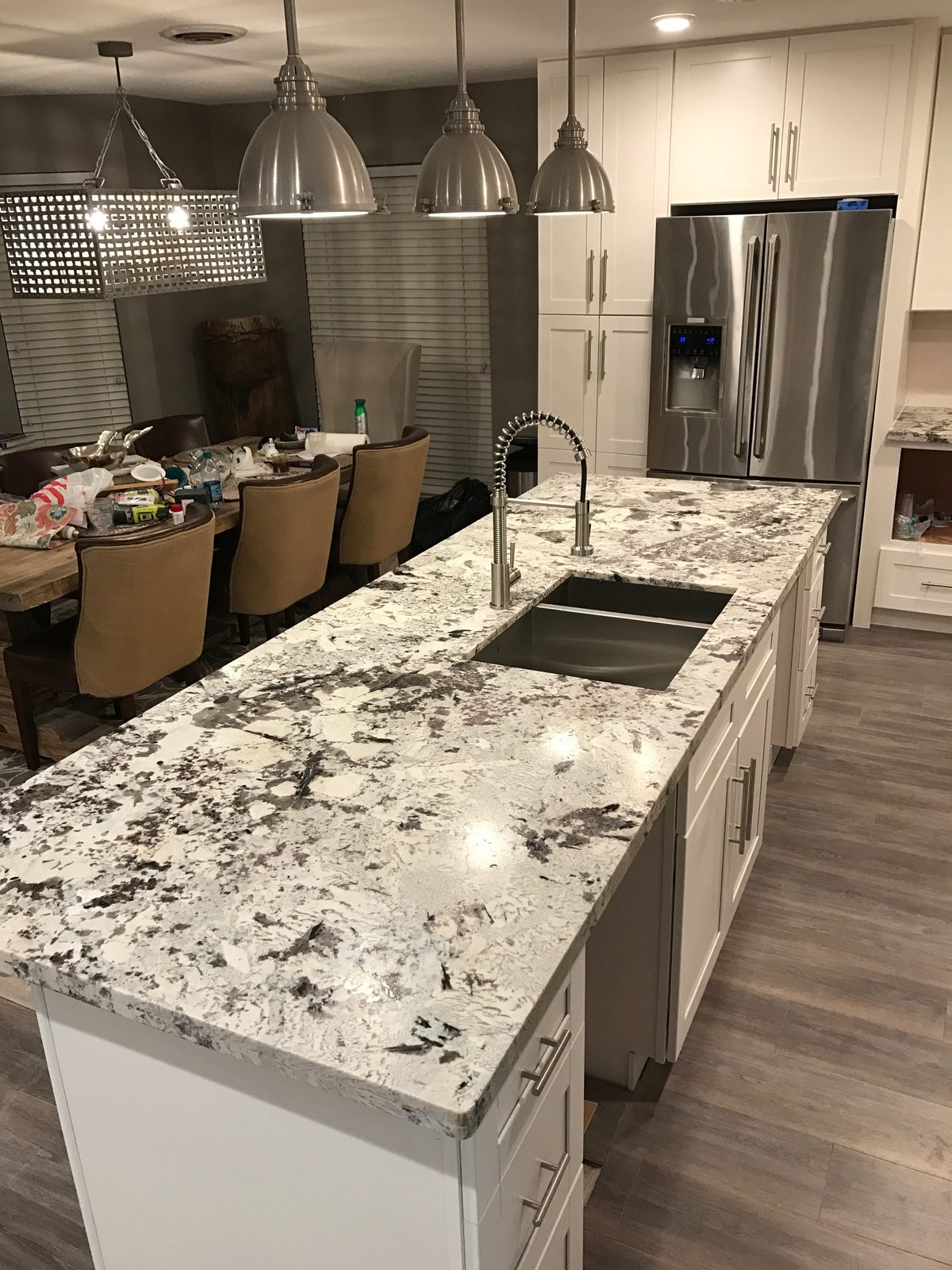 Custom kitchen by Haven Renovations — stone island with pendant lighting