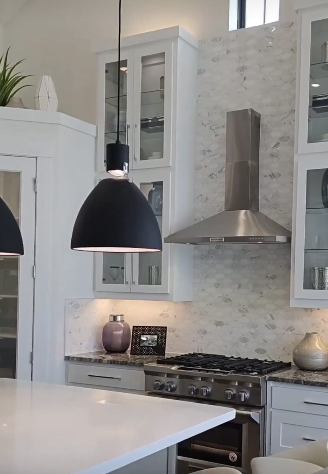 Custom kitchen by Haven Renovations — vent hood with glass-front uppers